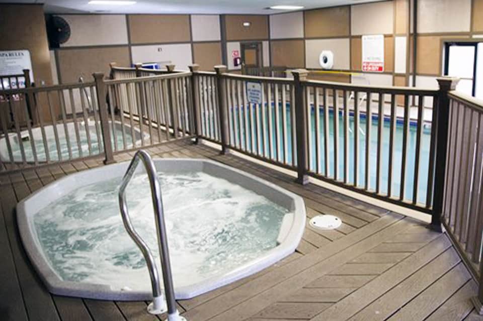 Indoor hot tub with jets on wooden deck surrounded by safety railings