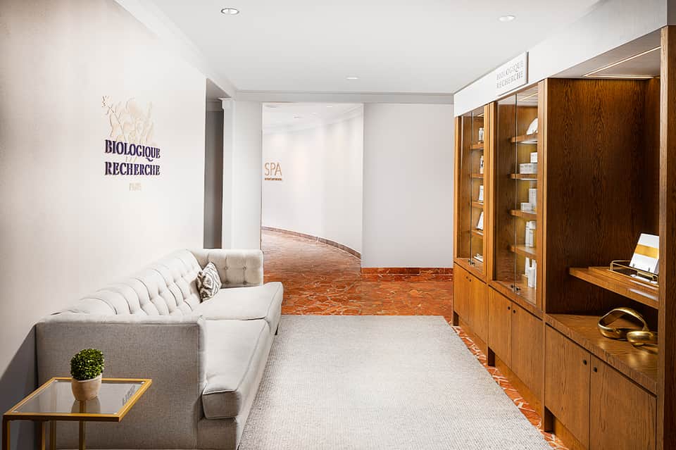 Luxury spa entrance with modern furniture, wood cabinetry, and elegant neutral décor