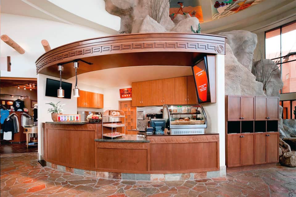 Circular indoor café counter with wooden accents and large stone sculpture overhead
