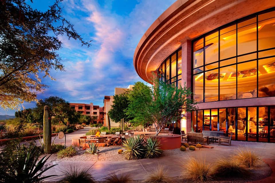 Desert resort building at dusk with saguaro cactus and warm lighting