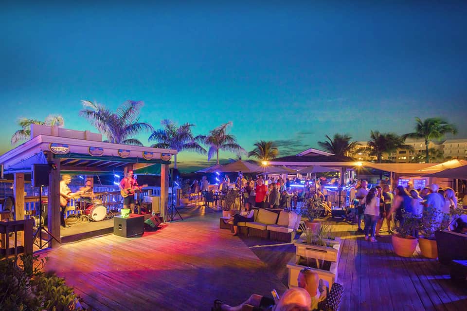 Beachfront resort event at night with live band, colorful lighting, and dancing guests