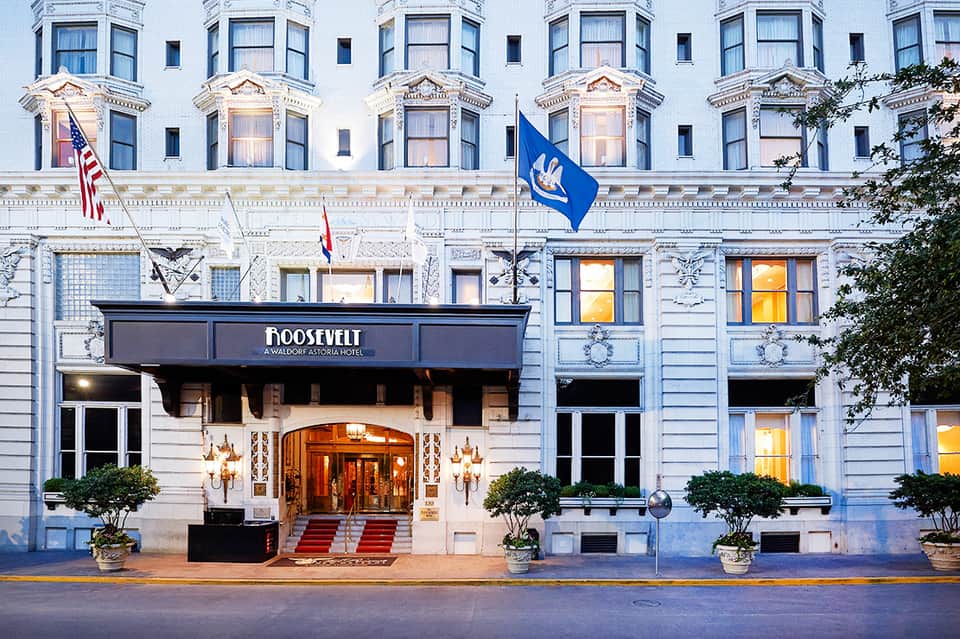 Historic Roosevelt Hotel facade with classical architecture and blue service flag