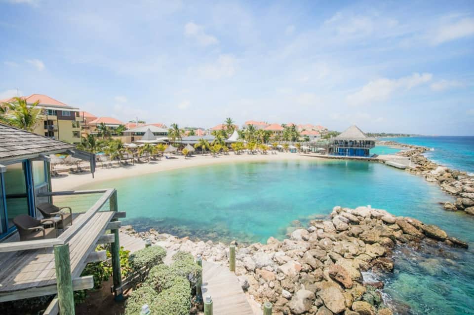 Beachfront resort cove with crystal-clear turquoise water and residential buildings