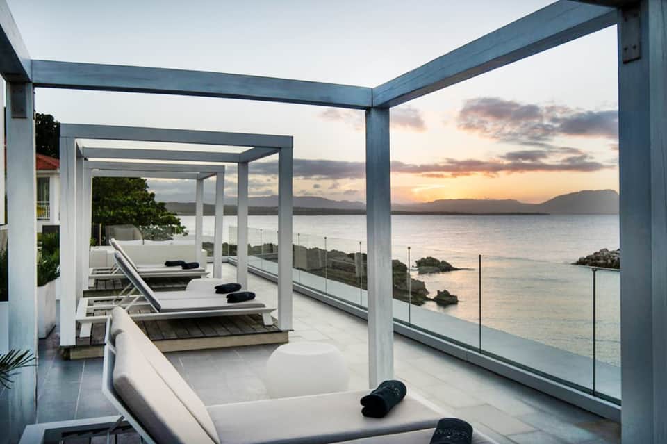 Modern seaside terrace with loungers and sunset ocean view