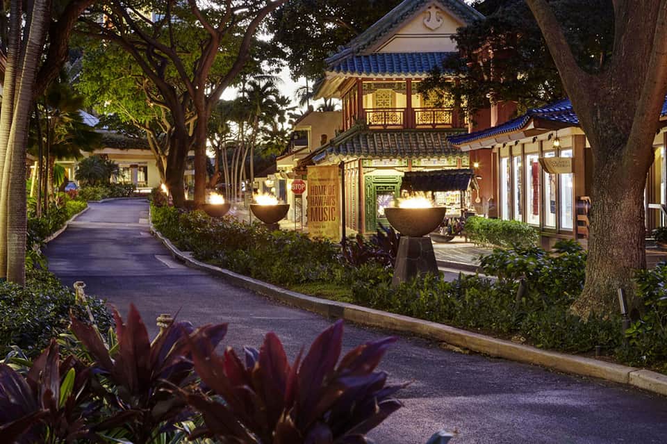 Illuminated evening pathway through tropical resort with Asian-inspired architecture and landscaping