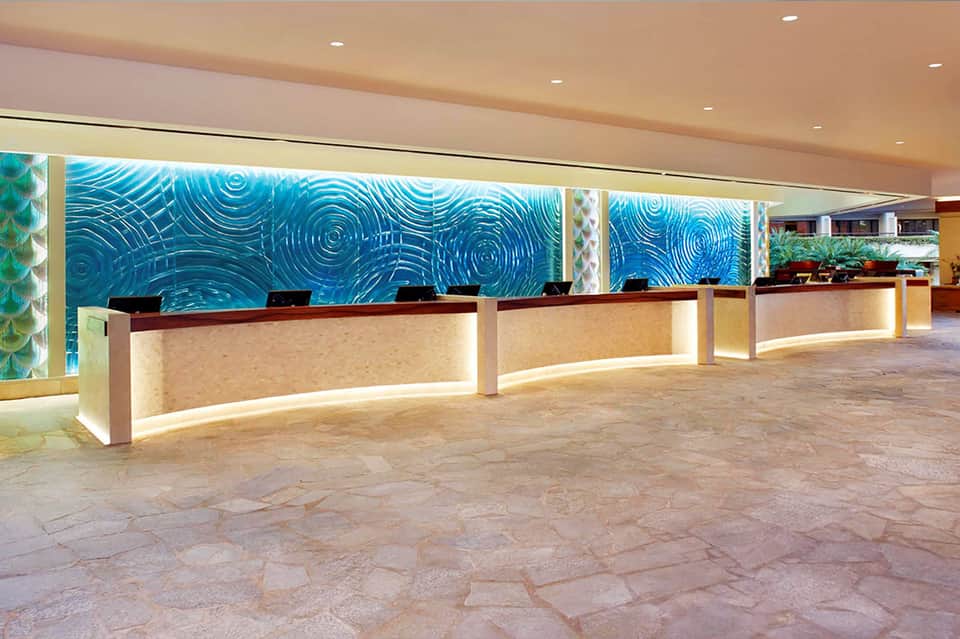 Modern resort reception desk with blue water-inspired artwork and multiple counters