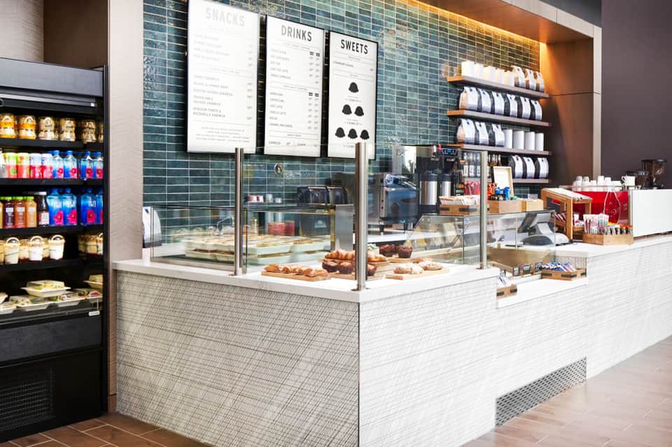 Contemporary coffee shop counter with menu boards and pastry display case