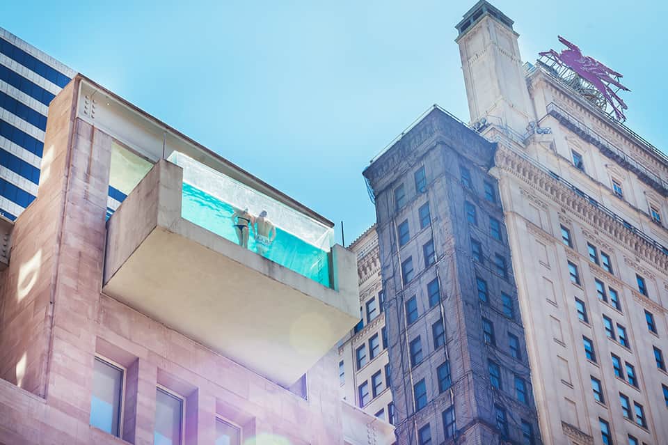 Modern turquoise glass balcony on contemporary building among historic urban architecture