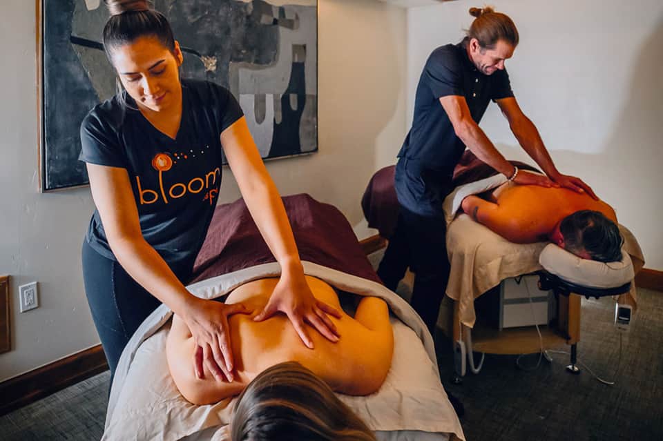 Massage therapy session at spa with therapists working on clients