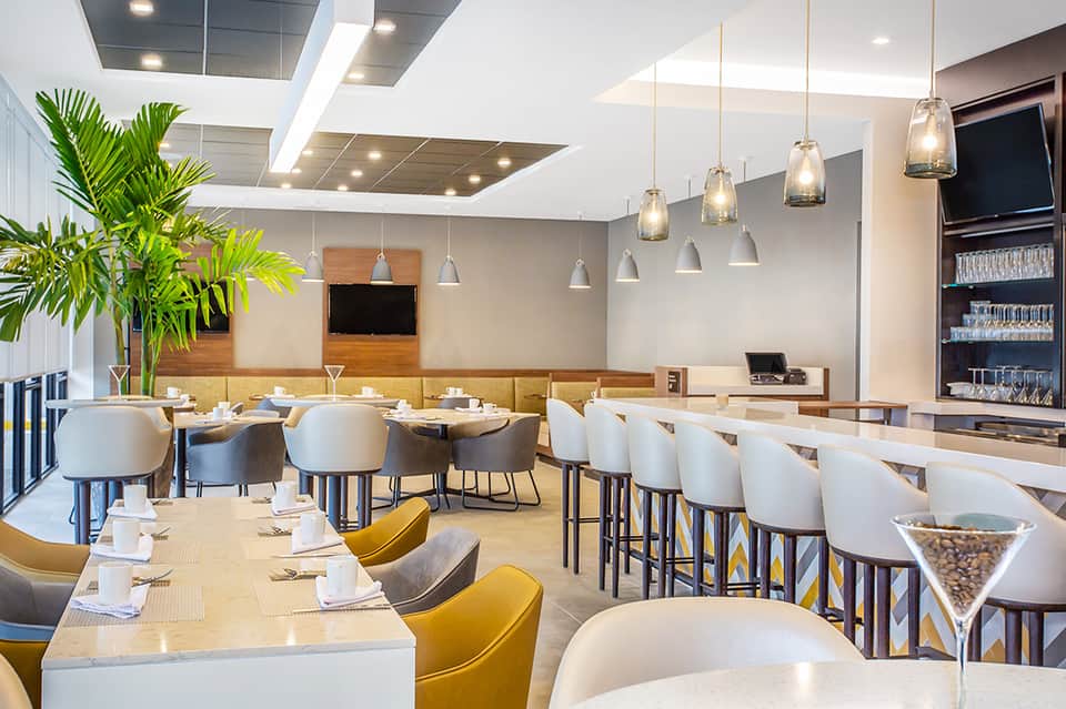 Modern restaurant interior with yellow and white chairs, pendant lighting, and contemporary design