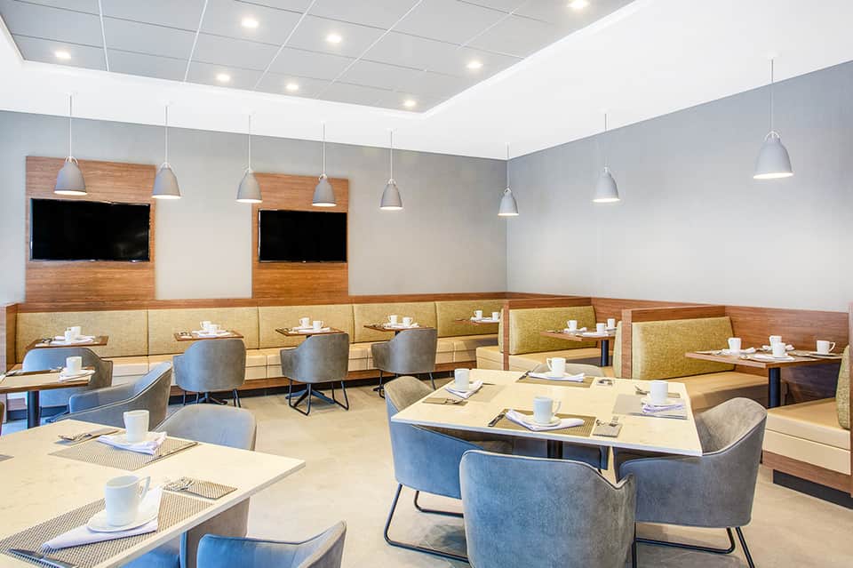 Modern restaurant interior with booth seating, pendant lights, and wood accents