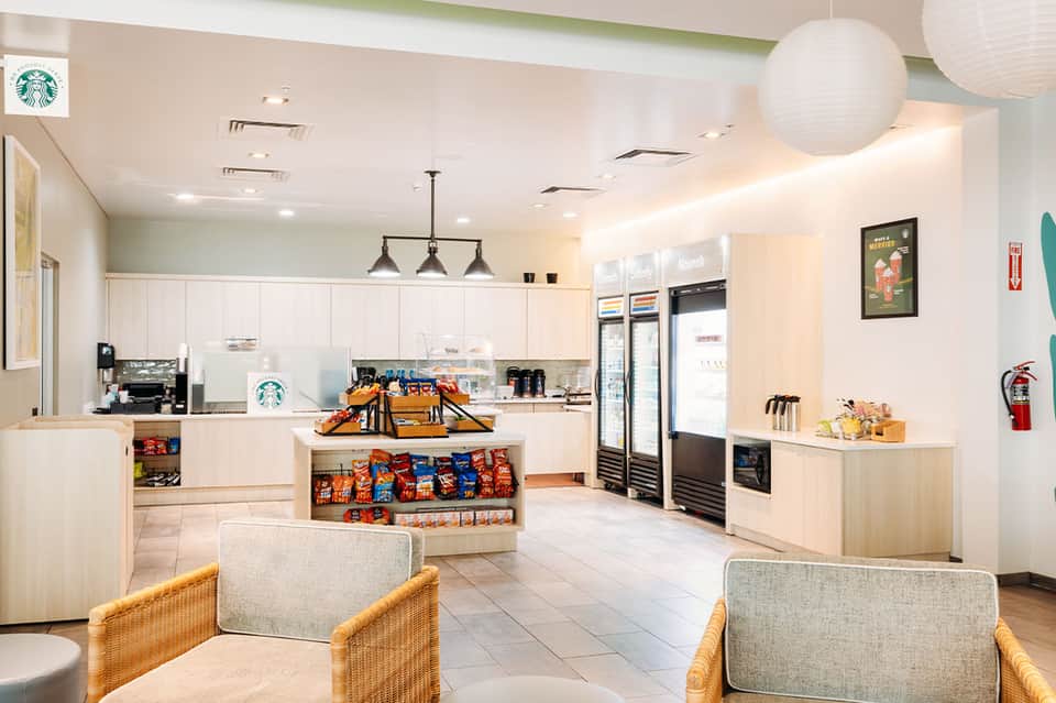 Bright modern Starbucks café interior with white cabinetry, seating area, and merchandise display