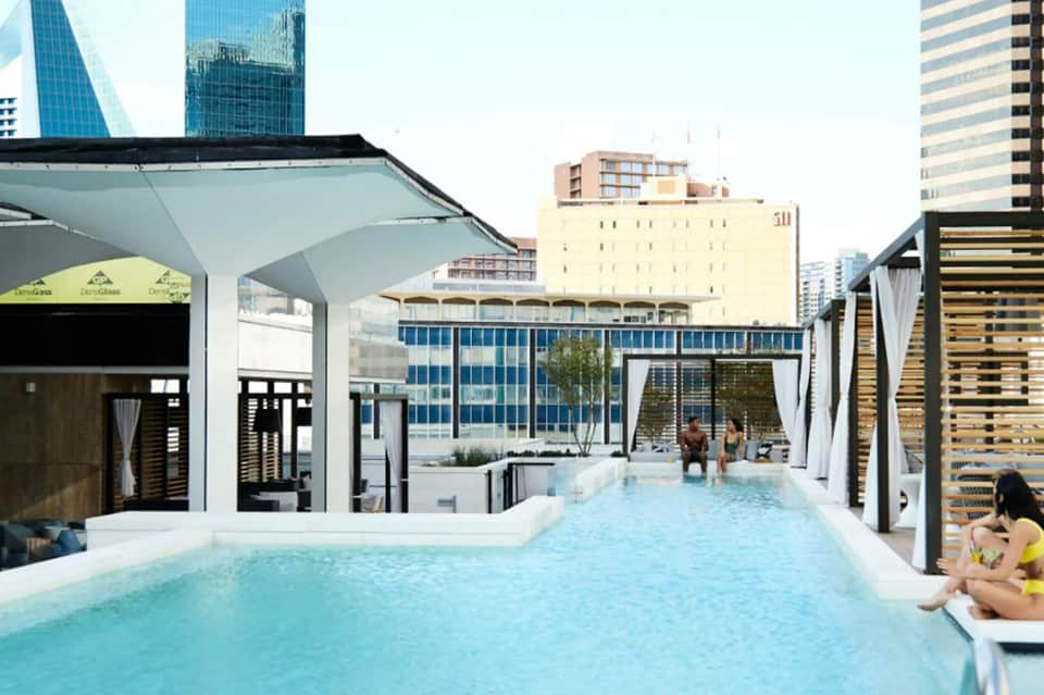 Modern rooftop pool with city skyline views and cabanas