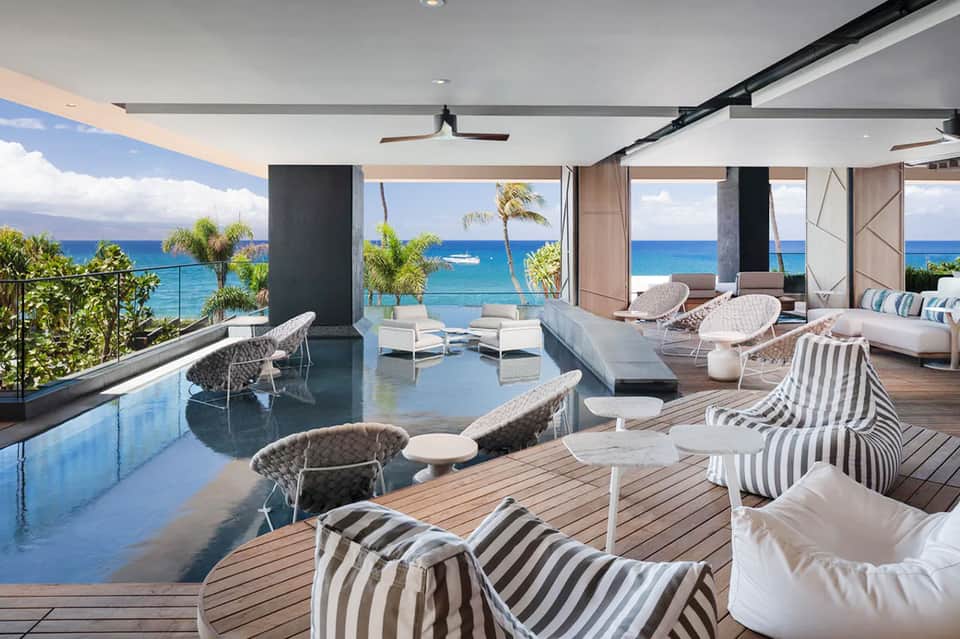 Luxury oceanfront terrace with pool, lounge chairs, and turquoise ocean view