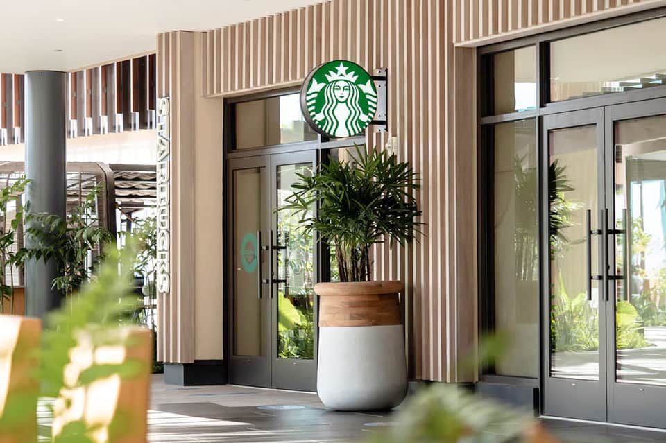 Modern Starbucks storefront in resort with vertical slat design and potted plants