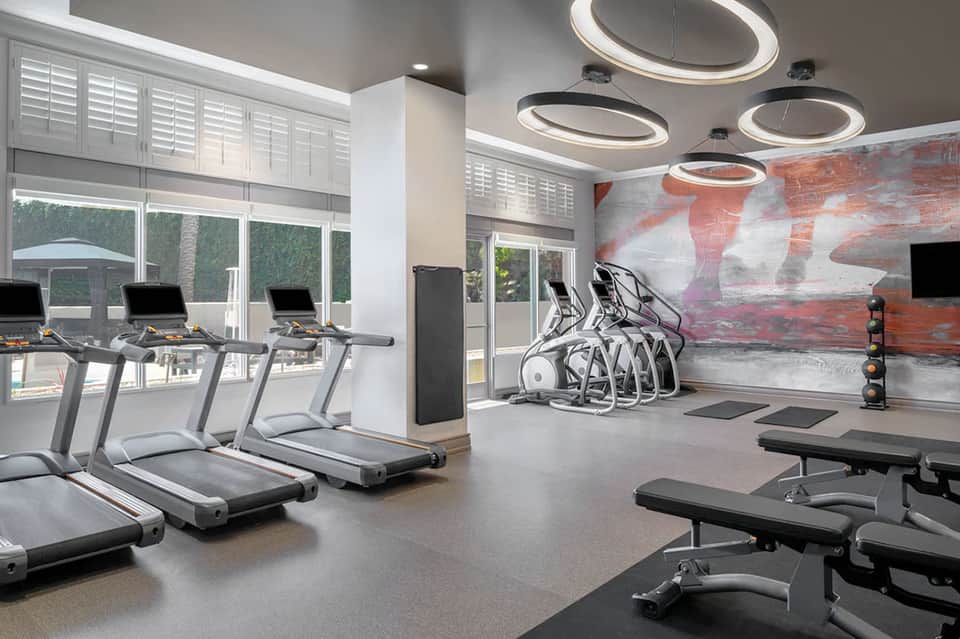 Contemporary hotel fitness center with treadmills and exercise equipment