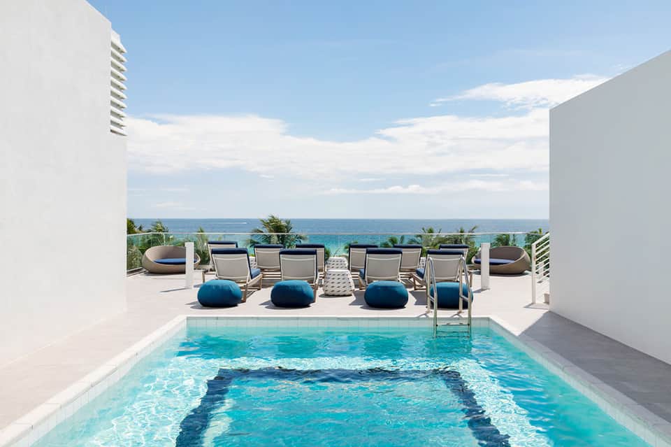 Private rooftop pool overlooking ocean with lounge chairs and sea view