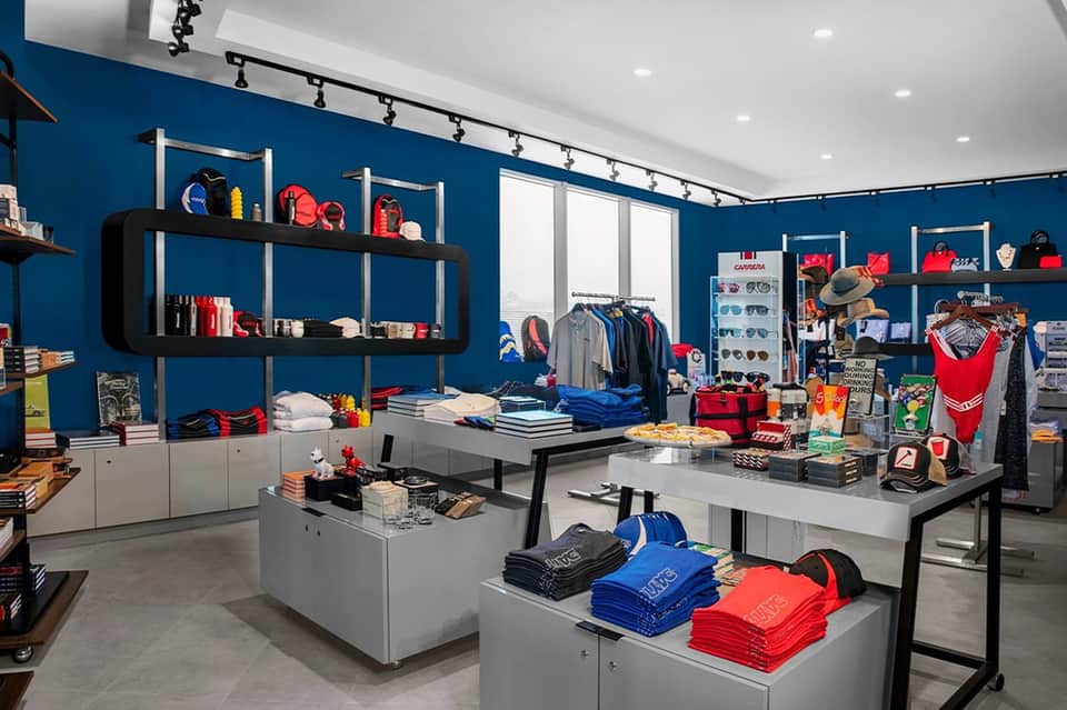 Modern retail shop interior with bold blue walls, clothing displays, accessories, and merchandise shelving