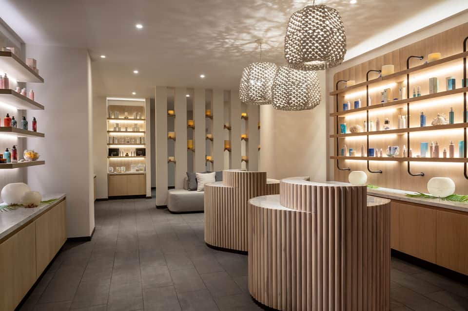 Modern spa reception area with wooden shelving and pendant lighting