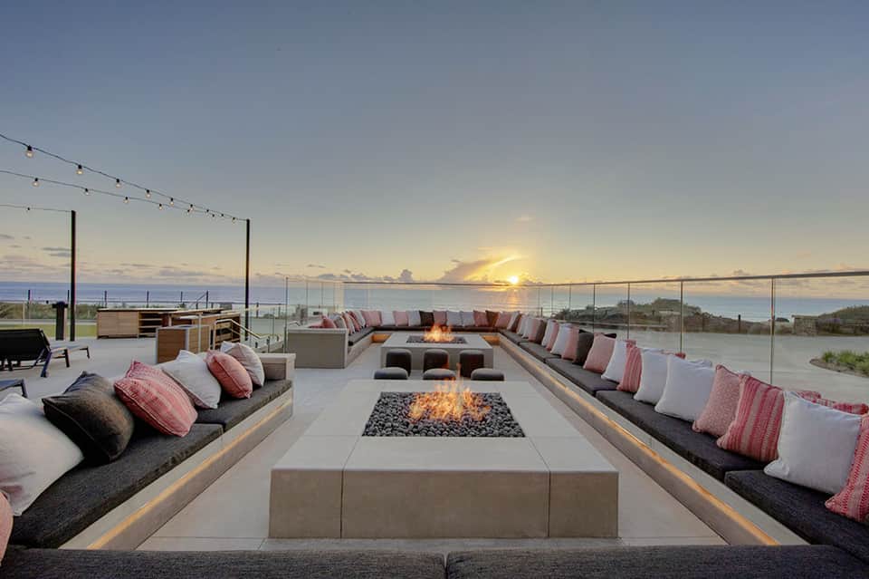 Sunset fire pit lounge with built-in seating, cushions, and waterfront views