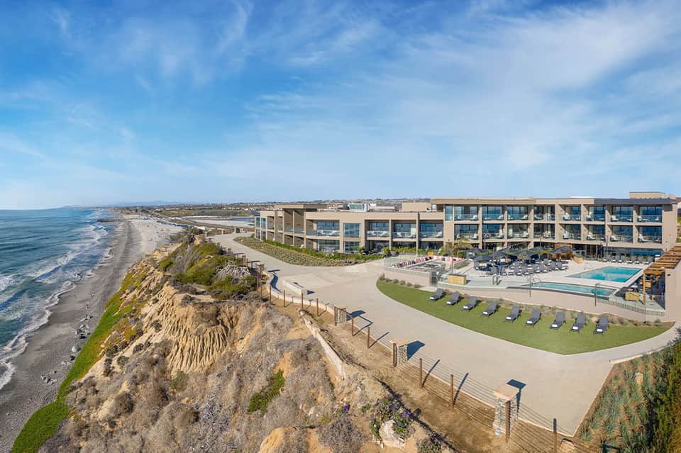Modern beachfront resort building perched on coastal cliffs with ocean and beach views