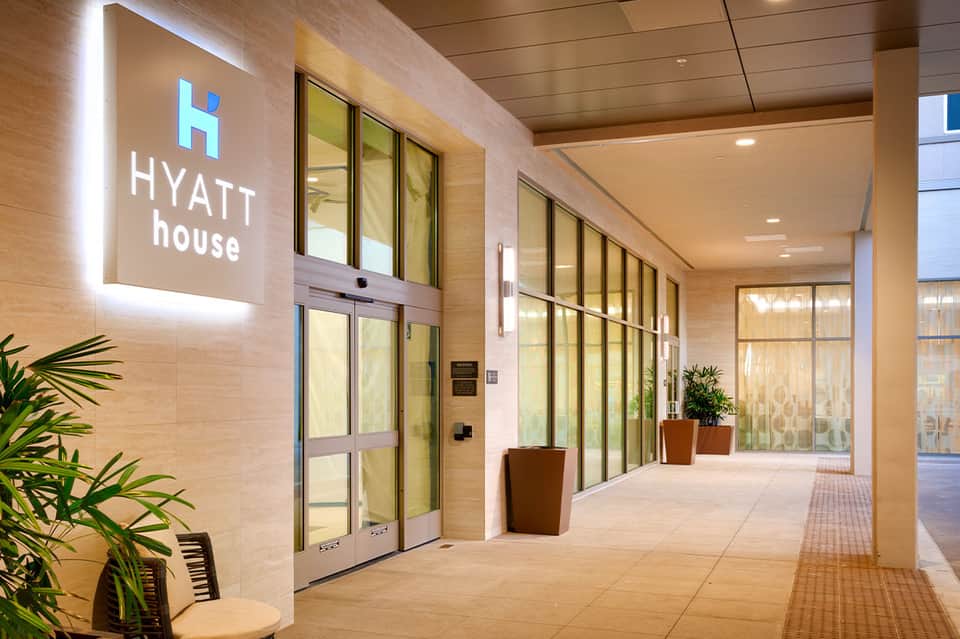 Hyatt house hotel entrance with illuminated signage, glass doors, and modern corridor design