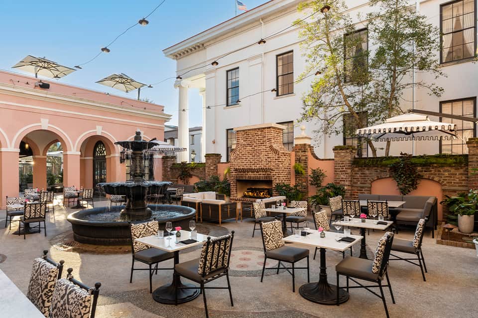 Upscale courtyard with fountain, fireplace, and sophisticated seating areas surrounded by architecture