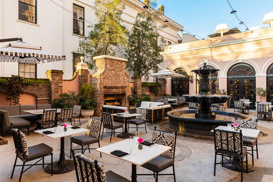 Upscale courtyard with fireplace, lounge seating, brick buildings, and ivy-covered walls