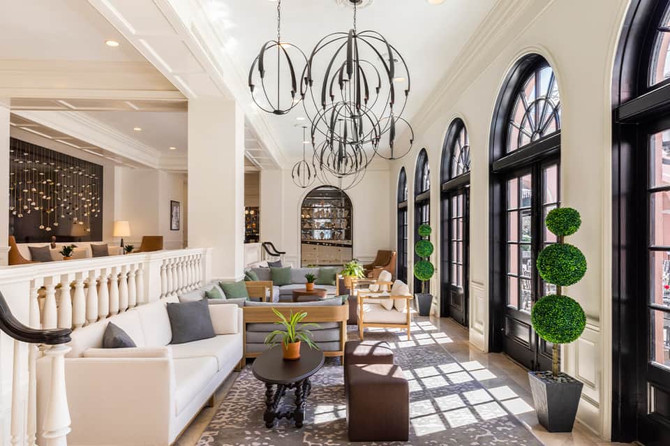 Elegant hotel lobby with high ceilings, modern chandelier, and arched windows