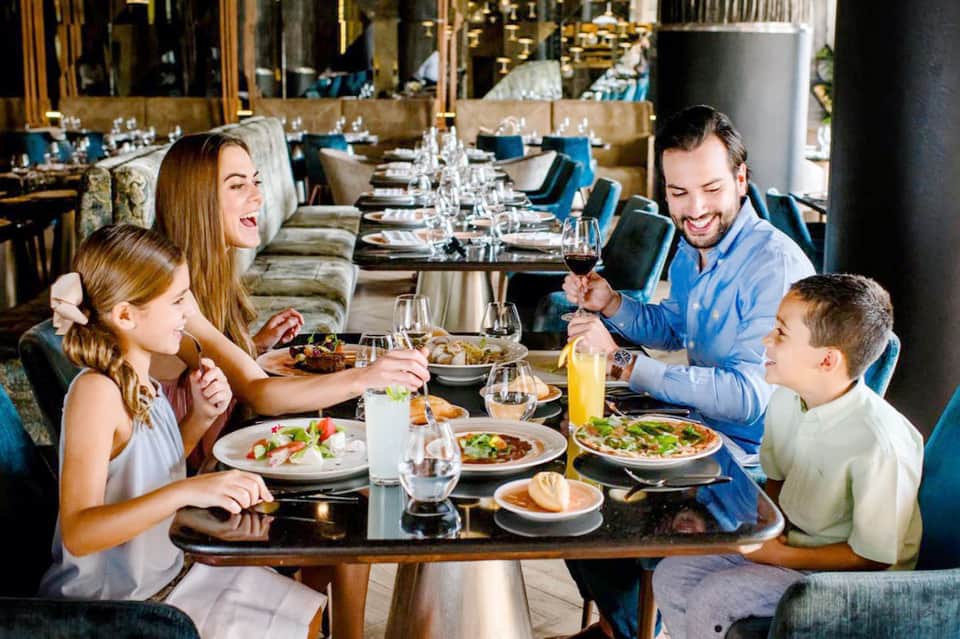 Family dining at upscale restaurant with elegant table settings and gold accents