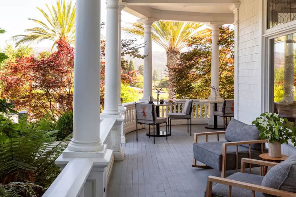 Covered porch with columns, lounge seating, and mountain landscape views