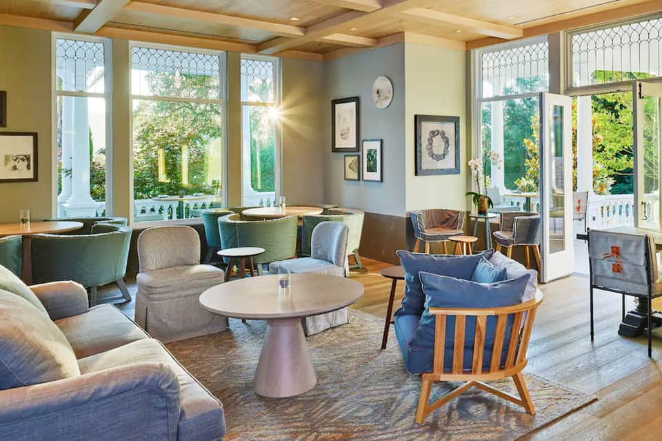 Modern hotel lounge with comfortable seating, large windows, and natural light
