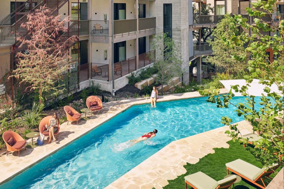 Modern resort courtyard pool with contemporary architecture and colorful lounge chairs
