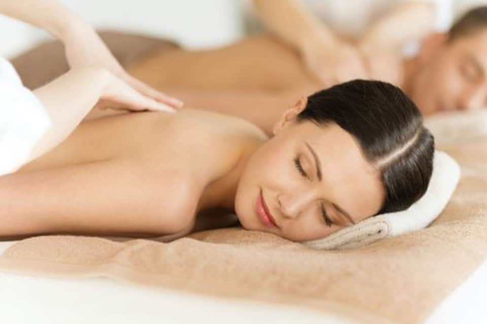 Professional massage therapist performing back massage on client