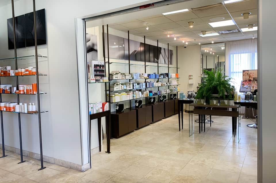 Modern spa retail boutique with glass storefront, product displays, and minimalist design