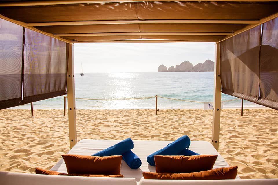 Beachfront cabana with ocean view and lounge seating on sandy beach