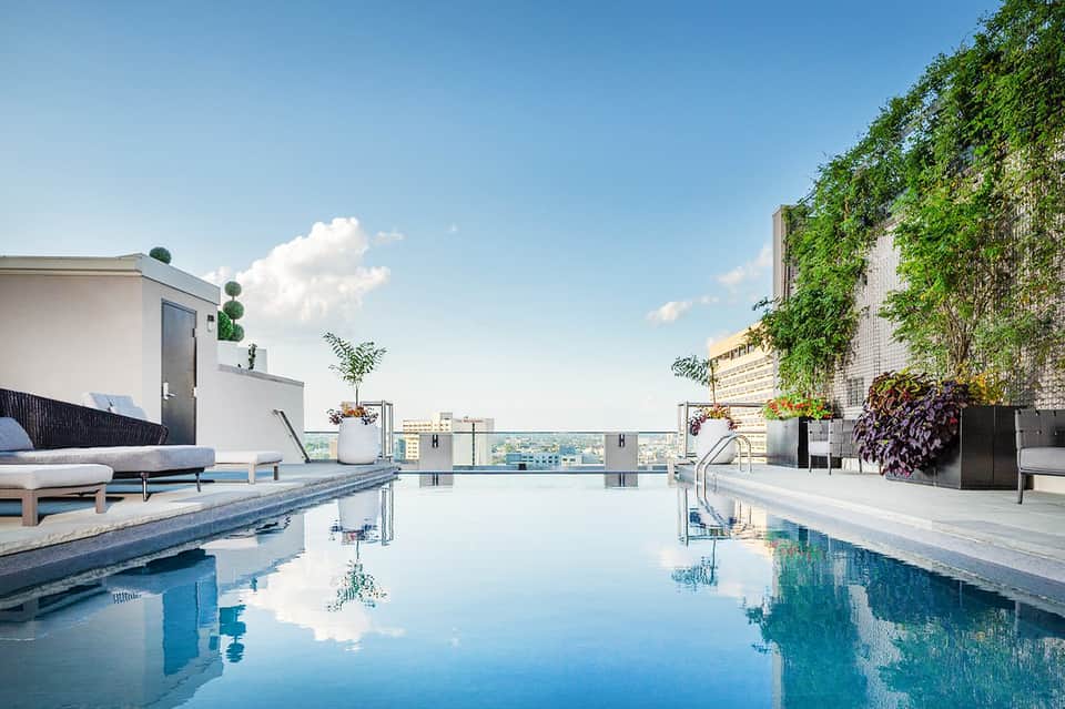 Rooftop infinity pool with city skyline views and modern lounging area