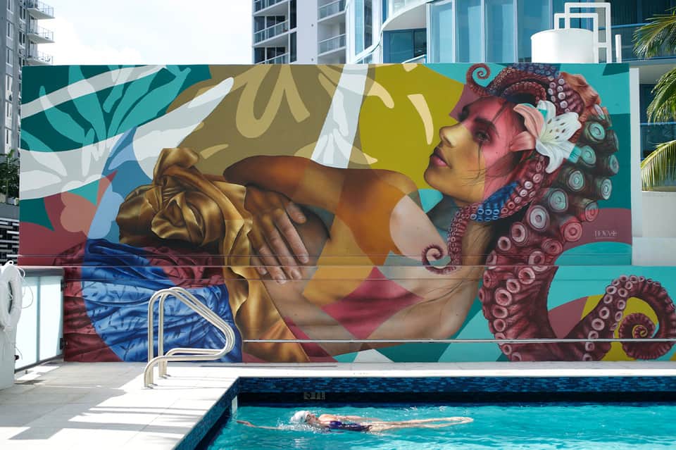Resort pool area with colorful octopus mural and swimmer in foreground