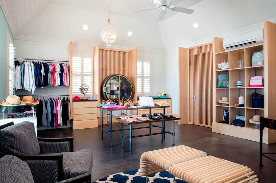Upscale resort boutique interior with wooden shelving, clothing racks, and elegant furnishings