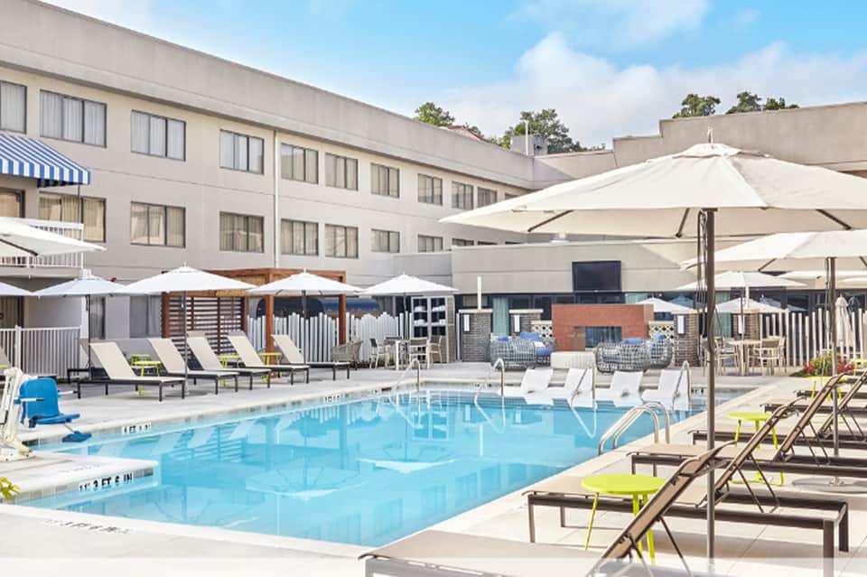 Resort pool with loungers, umbrellas and hotel building backdrop