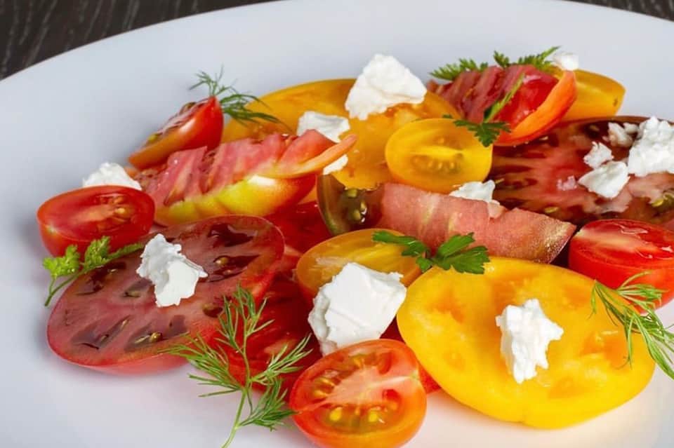 Colorful heirloom tomato salad with fresh mozzarella and herbs