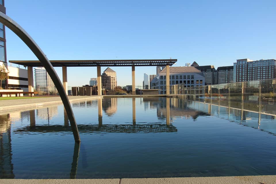 Outdoor infinity pool reflecting urban skyline with modern architectural structures