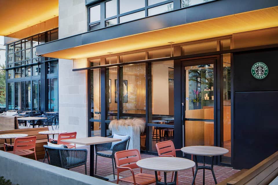 Modern Starbucks Coffee storefront with outdoor seating on a contemporary patio