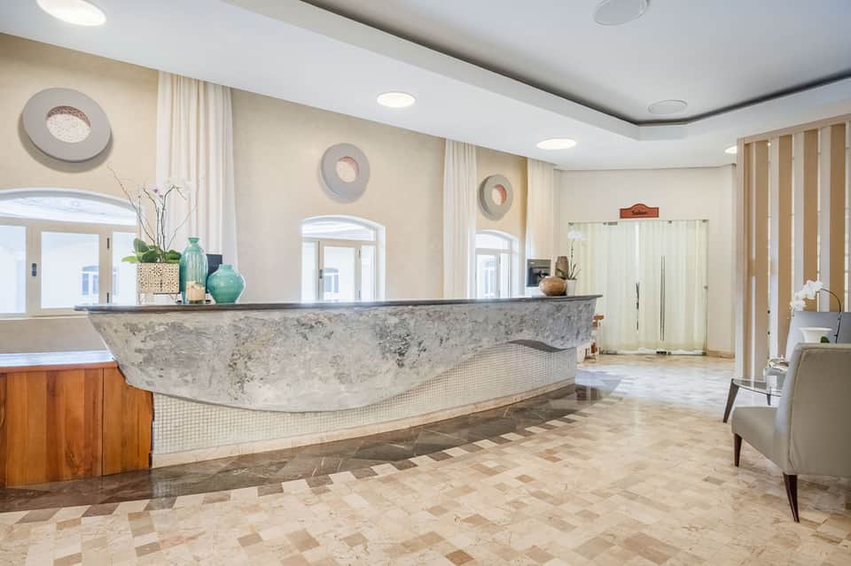 Elegant hotel lobby with curved marble reception desk, arched doorways, and sophisticated décor