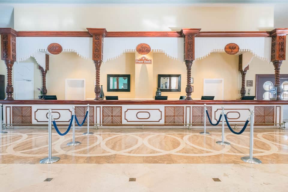 Ornate hotel front desk with decorative wooden columns and carved details