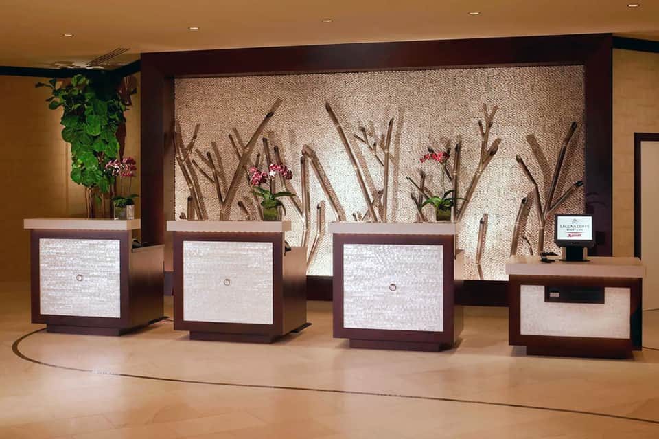 Modern resort lobby with multiple reception desks and decorative wall art