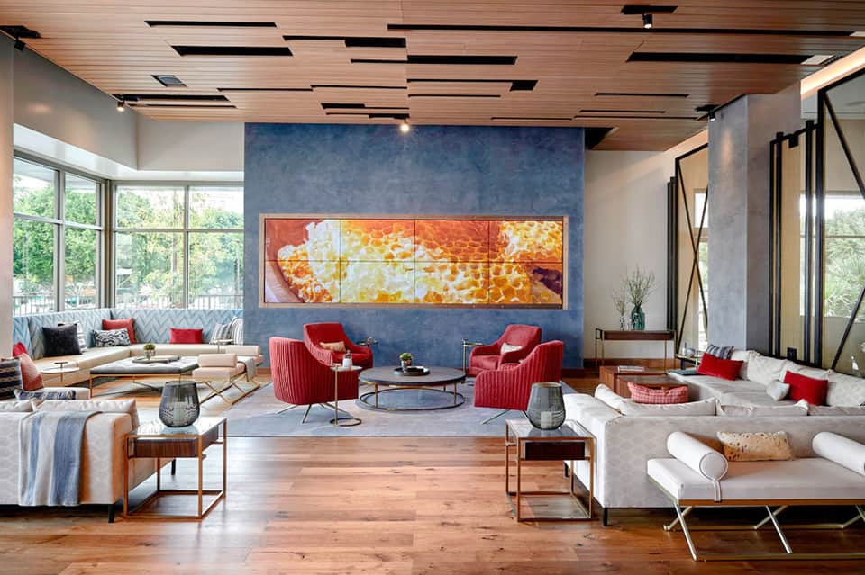 Contemporary resort lounge with red chairs, blue accent wall, and modern artwork
