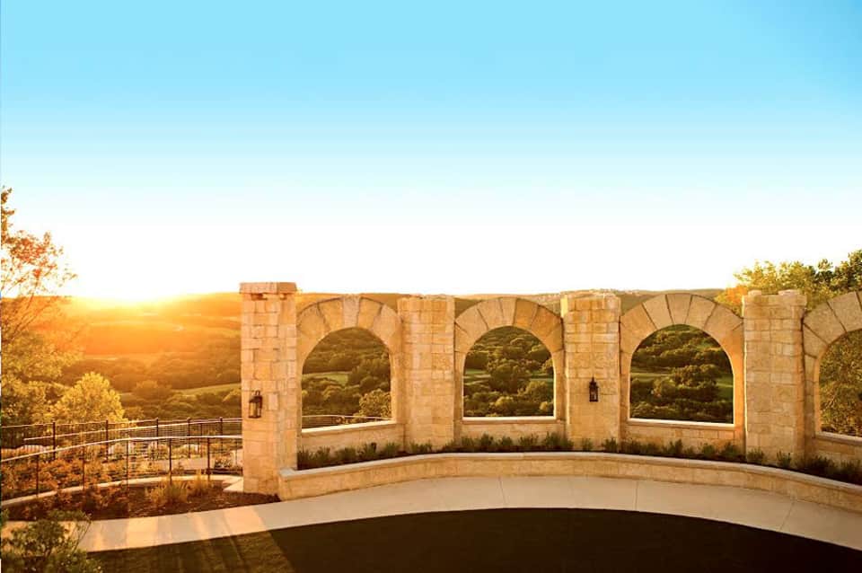 Stone archway viewpoint overlooking forested landscape at golden hour