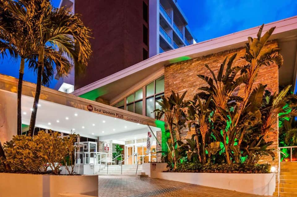Best Western Plus hotel entrance at dusk with illuminated signage and palm trees
