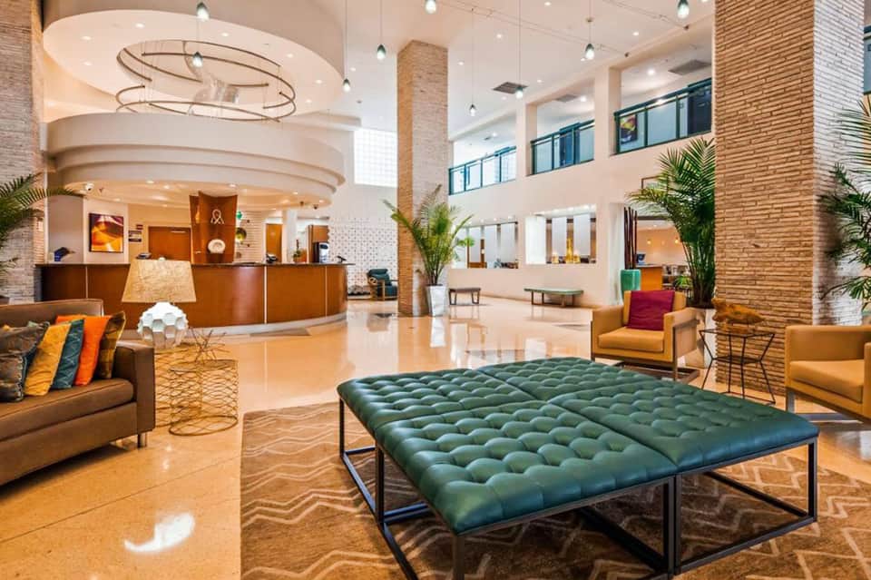 Modern hotel lobby with circular ceiling detail, comfortable seating, and reception desk